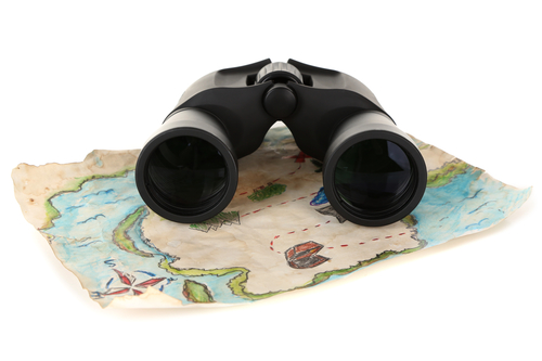 Black modern binoculars with map of adventure isolated on white